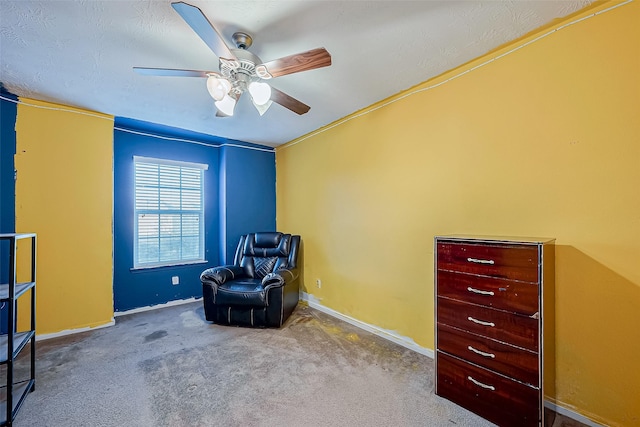 sitting room with ceiling fan and carpet flooring