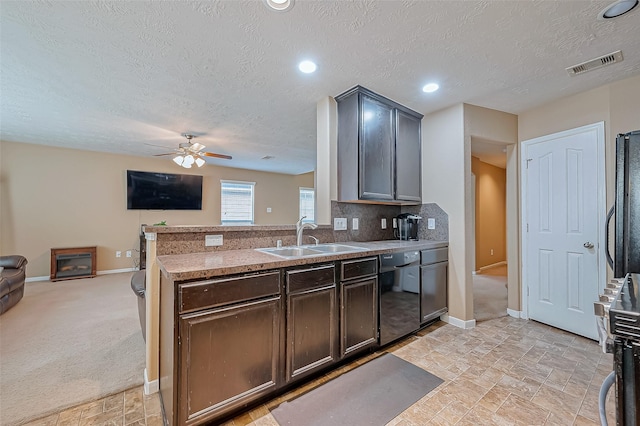 kitchen featuring dishwasher, sink, light carpet, and a textured ceiling