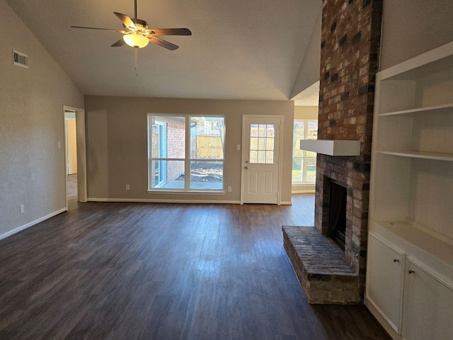 unfurnished living room with lofted ceiling, dark wood-type flooring, ceiling fan, and a brick fireplace