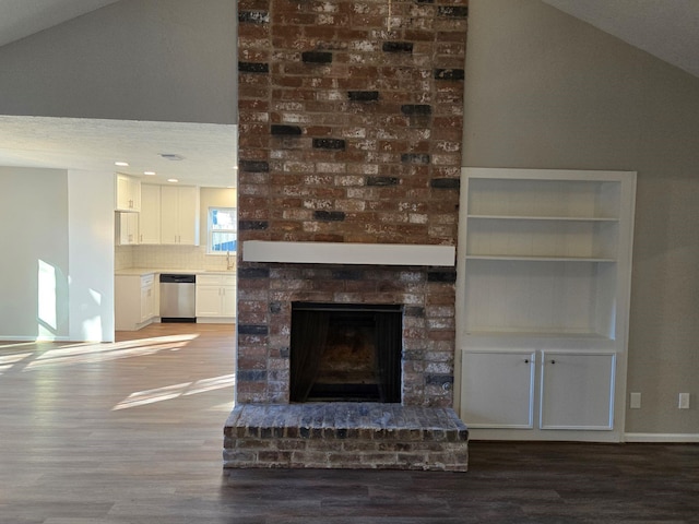 unfurnished living room featuring lofted ceiling, hardwood / wood-style floors, and a fireplace