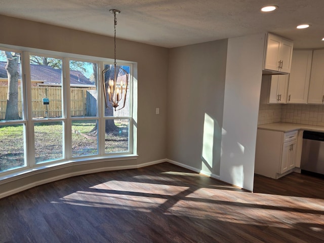 unfurnished dining area featuring dark hardwood / wood-style flooring and a chandelier