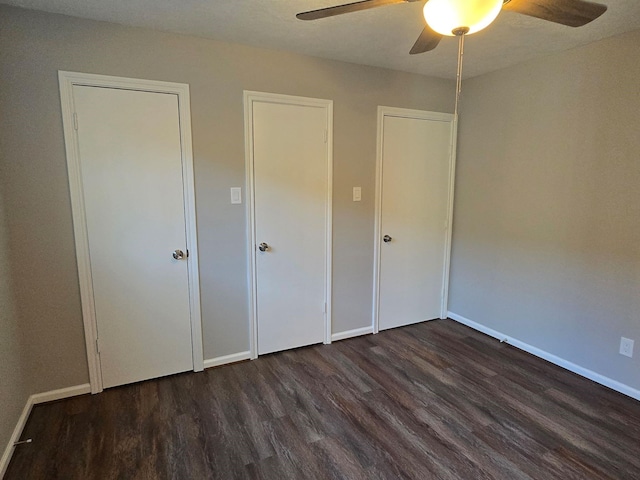 unfurnished bedroom featuring dark wood-type flooring and ceiling fan