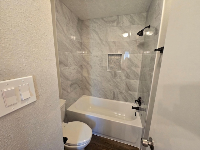 bathroom with tiled shower / bath combo, hardwood / wood-style floors, and toilet