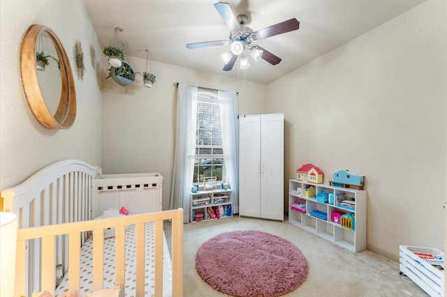 bedroom with carpet floors, a nursery area, and ceiling fan