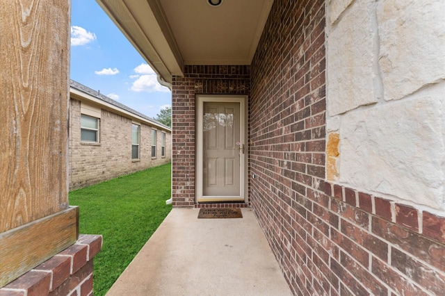 view of exterior entry with a yard