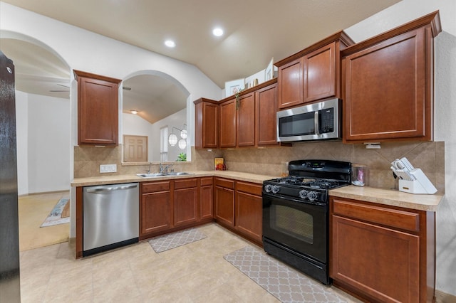 kitchen featuring lofted ceiling, appliances with stainless steel finishes, sink, and decorative backsplash