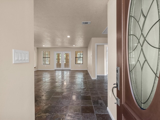 entryway with french doors and a textured ceiling