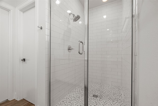 bathroom featuring hardwood / wood-style flooring and a shower with shower door