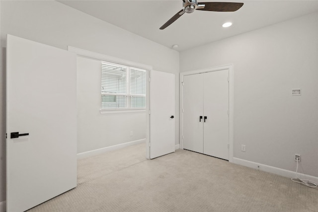 unfurnished bedroom with ceiling fan, light carpet, and a closet