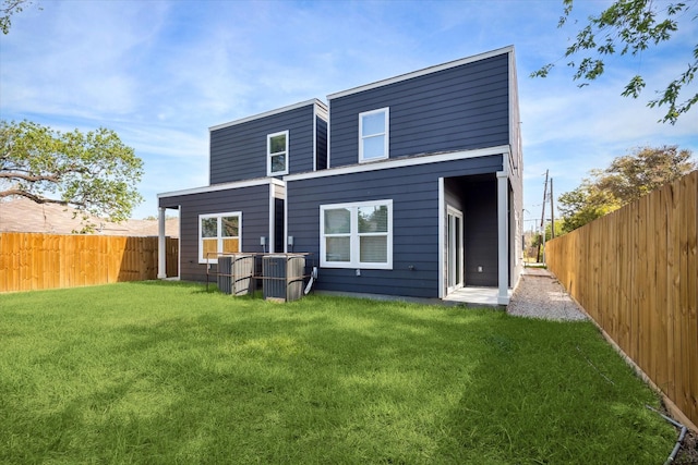 rear view of house with a yard and central air condition unit