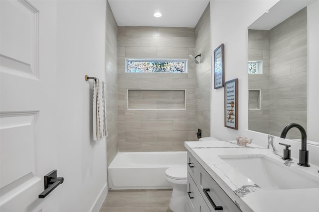 full bathroom featuring vanity, tiled shower / bath combo, toilet, and hardwood / wood-style flooring