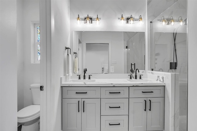 bathroom with vanity, toilet, and a shower with door