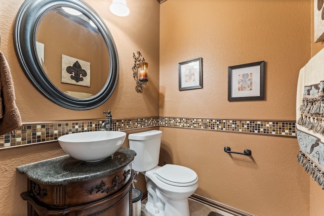 bathroom with vanity, tasteful backsplash, and toilet