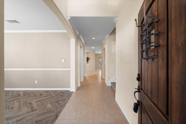 hall with crown molding and light tile patterned floors