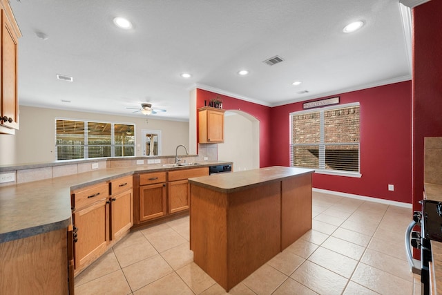 kitchen featuring ornamental molding, kitchen peninsula, sink, and a kitchen island