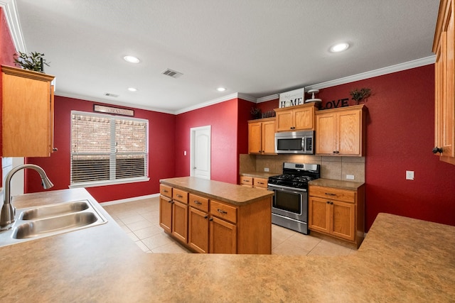 kitchen with light tile patterned flooring, ornamental molding, stainless steel appliances, and sink