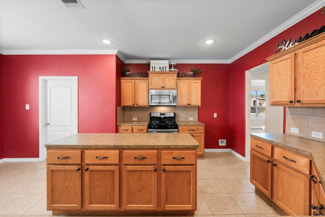 kitchen with decorative backsplash, ornamental molding, a center island, and appliances with stainless steel finishes