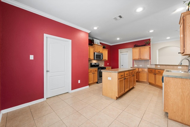 kitchen with sink, crown molding, a kitchen island, and appliances with stainless steel finishes