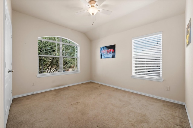 carpeted spare room with ceiling fan and vaulted ceiling