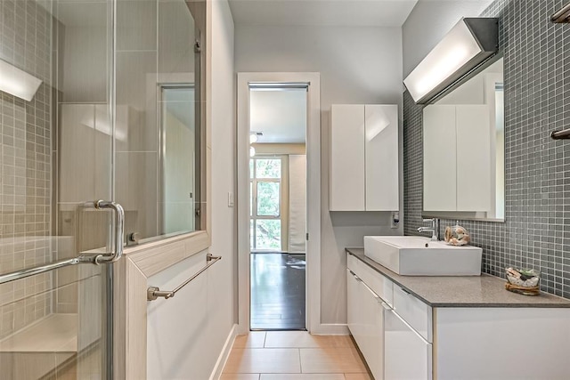 bathroom with vanity, decorative backsplash, tile patterned floors, and walk in shower