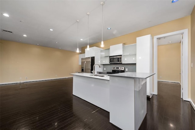 kitchen featuring sink, appliances with stainless steel finishes, a kitchen island with sink, white cabinetry, and decorative light fixtures