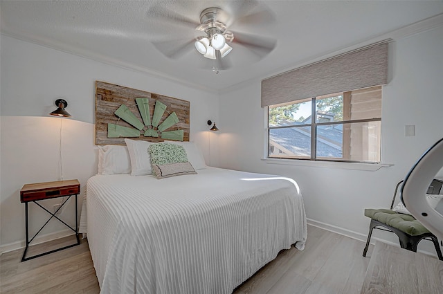 bedroom with crown molding, ceiling fan, and light wood-type flooring