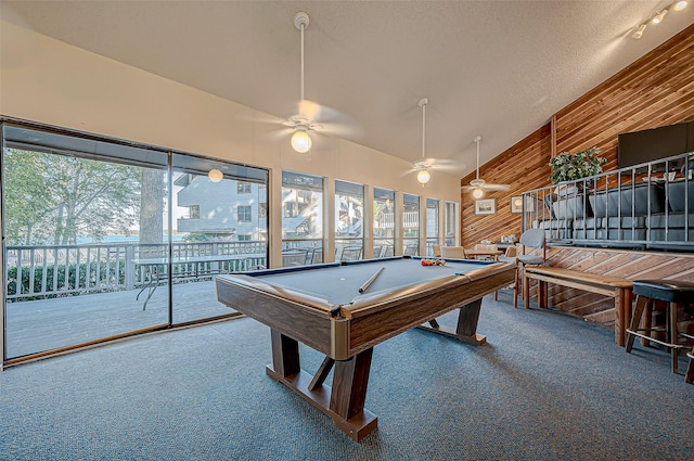 game room featuring pool table, carpet, a textured ceiling, and wood walls