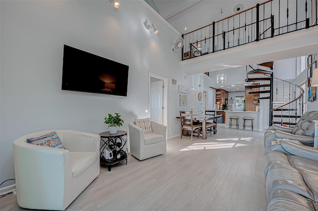 living room featuring a towering ceiling and light wood-type flooring