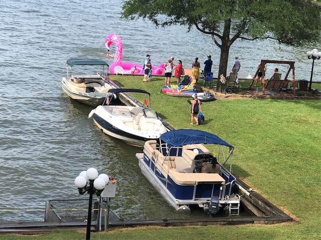 view of dock with a water view and a yard