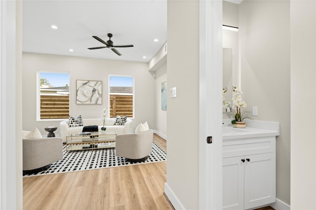 living room featuring ceiling fan and light hardwood / wood-style floors