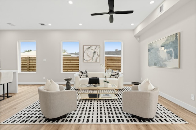 living room featuring a wealth of natural light, ceiling fan, and light hardwood / wood-style flooring