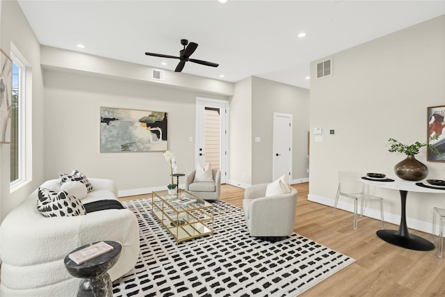 living room featuring light hardwood / wood-style floors and ceiling fan