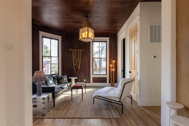 sitting room with wood-type flooring and wooden walls