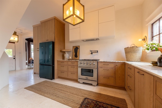 kitchen featuring hanging light fixtures, black fridge, white cabinets, and high end stainless steel range