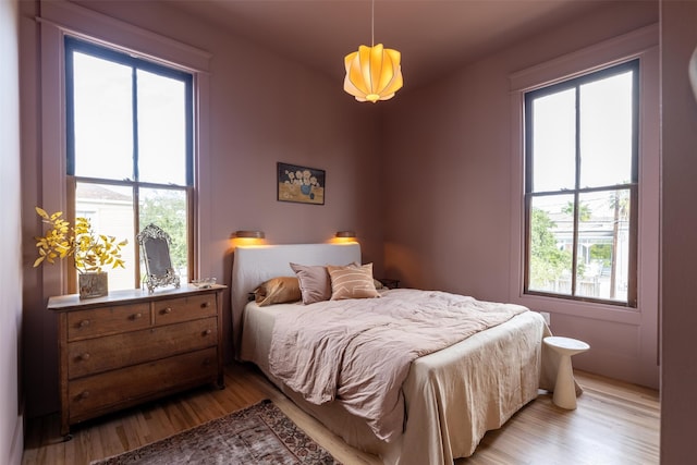 bedroom featuring multiple windows and light hardwood / wood-style floors