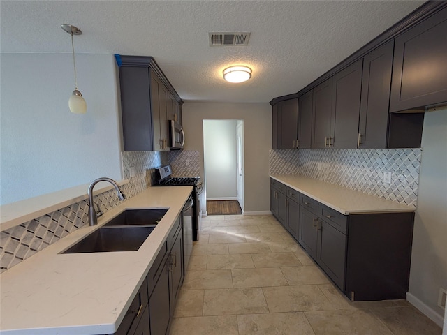 kitchen featuring pendant lighting, sink, light tile patterned floors, stainless steel appliances, and dark brown cabinets