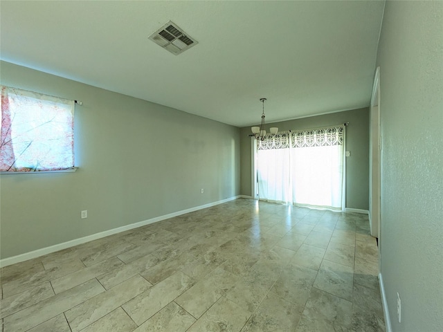 spare room featuring a chandelier