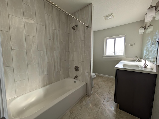 full bathroom featuring tiled shower / bath combo, vanity, a textured ceiling, and toilet