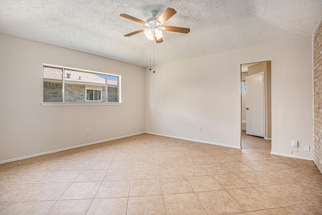 spare room with ceiling fan, a textured ceiling, and light tile patterned floors