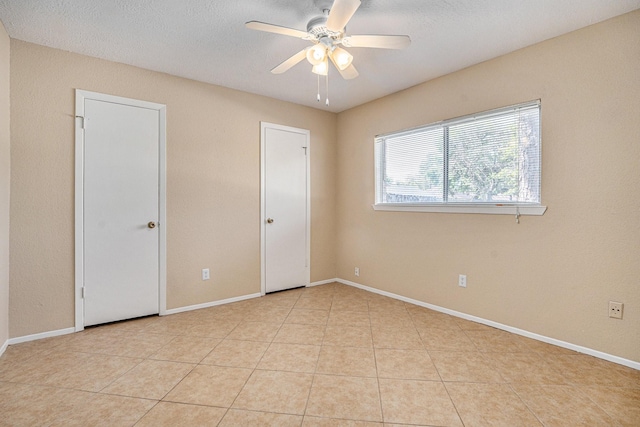 unfurnished room featuring light tile patterned floors and ceiling fan