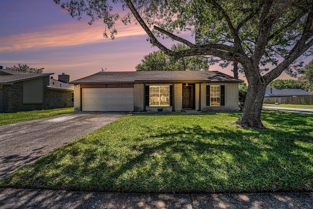 ranch-style home with a garage and a lawn