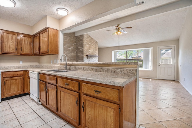 kitchen with white dishwasher, sink, a textured ceiling, and light tile patterned floors