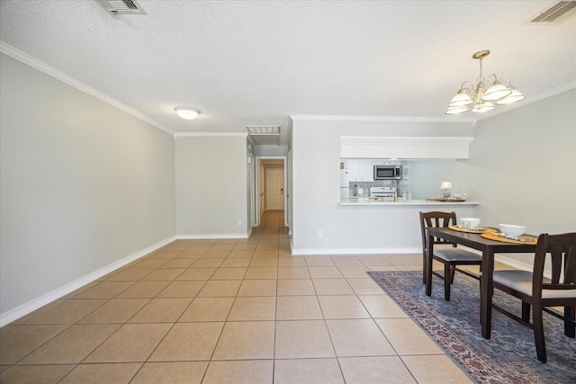 tiled dining space with ornamental molding, a textured ceiling, and a chandelier