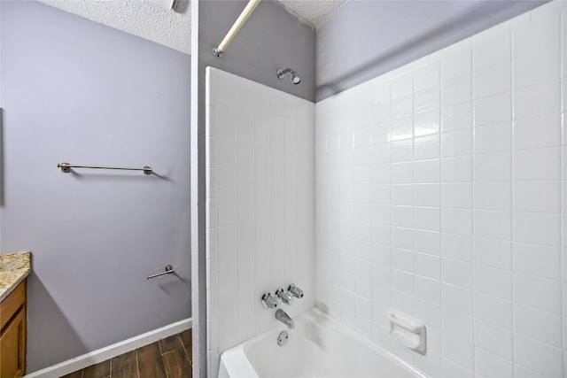 bathroom featuring vanity, shower / bath combination, hardwood / wood-style floors, and a textured ceiling