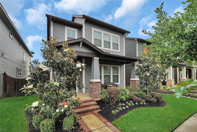 view of front of house with a porch and a front lawn