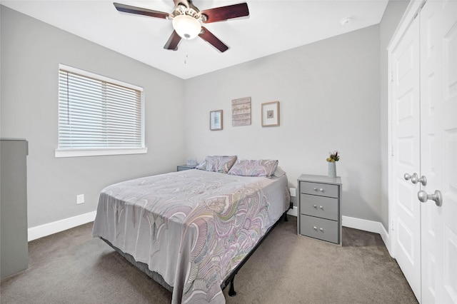 carpeted bedroom featuring ceiling fan and a closet