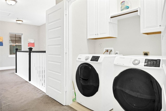 laundry room with cabinets, washer and dryer, and light colored carpet