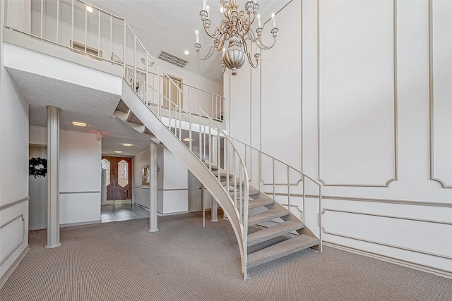 staircase featuring carpet floors and an inviting chandelier