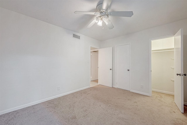 unfurnished bedroom with ceiling fan, light colored carpet, and a closet