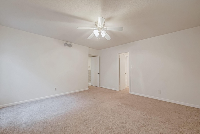 carpeted spare room featuring a textured ceiling and ceiling fan